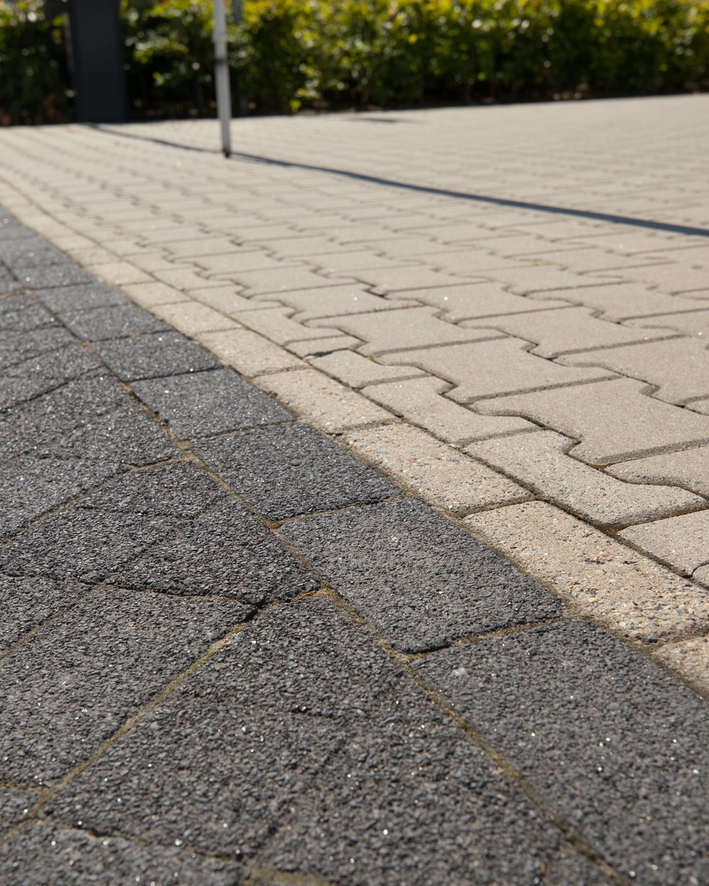 Detail van de klinkerbestrating waar twee steenkleuren op elkaar aansluiten