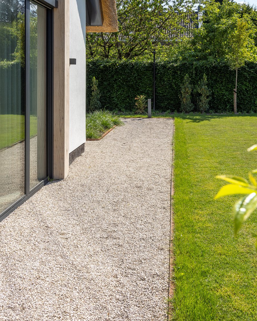 Tuinpad langs een gazon naar de woning